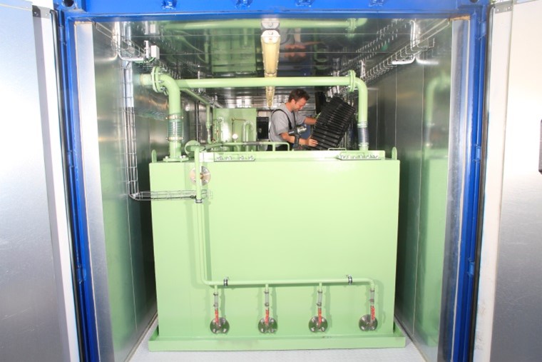 Picture of Bioreactor in container, with a work man on hand